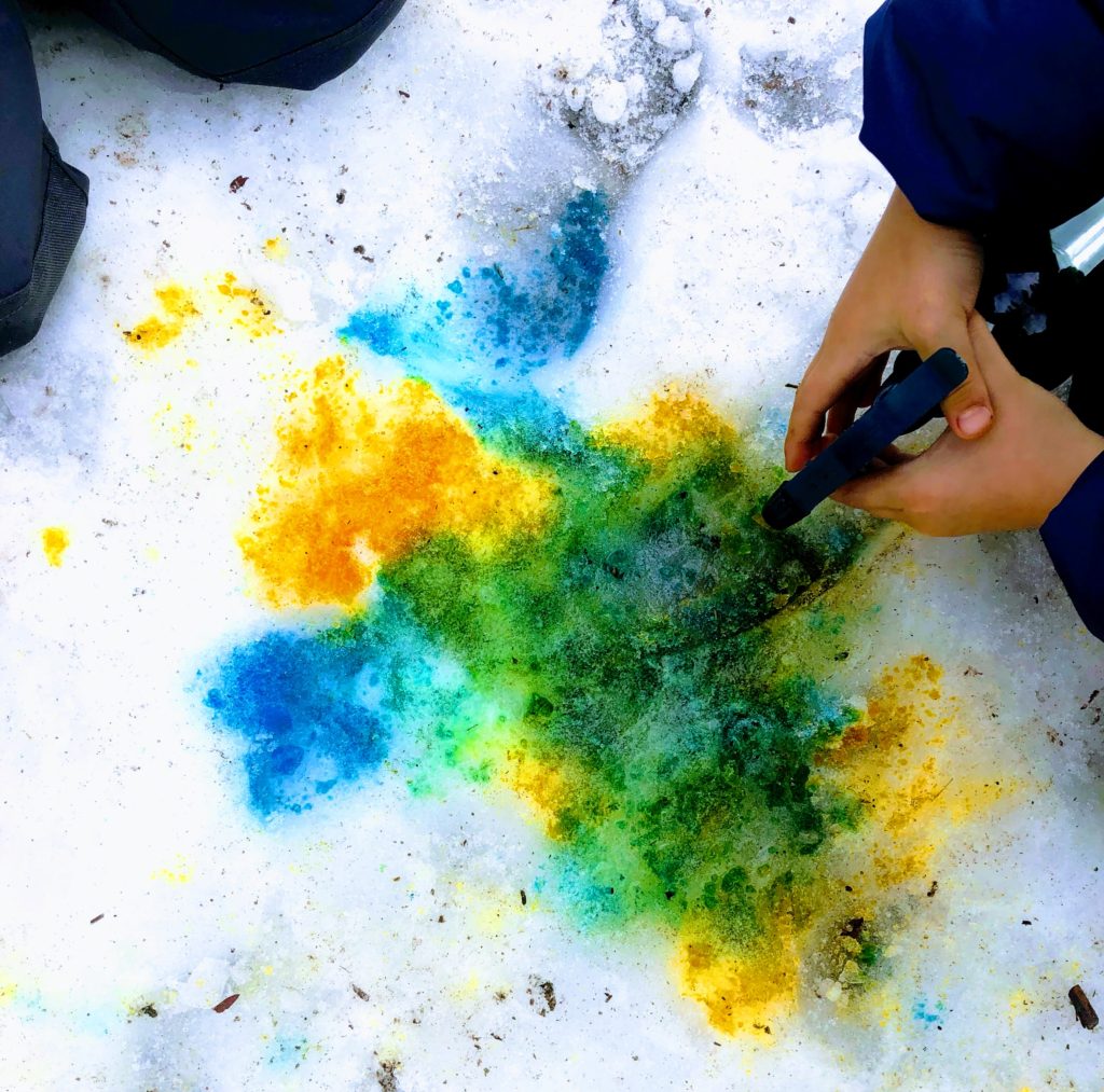 children creating secondary colours by mixing primary colours on snow